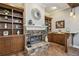 Cozy living room with a stone fireplace, built-in bookshelves, and a bar area, perfect for entertaining guests at 1877 Muirfield Way, Oldsmar, FL 34677