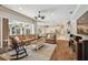 Bright, open-concept living room boasts hardwood floors, a large leather sectional, and access to the outdoor patio at 1877 Muirfield Way, Oldsmar, FL 34677