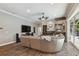 Large living room with wood floors, a comfortable sectional, a fireplace, and access to the outdoor living space at 1877 Muirfield Way, Oldsmar, FL 34677
