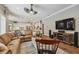 Spacious living room with wood floors, a large sectional sofa, and a view into the adjacent kitchen area at 1877 Muirfield Way, Oldsmar, FL 34677