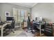 Well-lit home office with wood floors, plantation shutters, and dual workspaces at 1877 Muirfield Way, Oldsmar, FL 34677