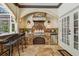 The outdoor kitchen with stone details includes a grill, bar, and mini-fridge, creating an inviting space for cooking and entertaining at 1877 Muirfield Way, Oldsmar, FL 34677