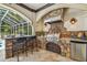 The outdoor kitchen has stone accents, a grill, a bar, and seating, making it an ideal space for entertaining guests at 1877 Muirfield Way, Oldsmar, FL 34677