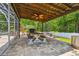 A covered patio features an outdoor kitchen, ceiling fan, dining table, and white fence providing an ideal space for outdoor enjoyment at 1877 Muirfield Way, Oldsmar, FL 34677
