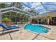 A screened-in pool area with lounge chairs and a hot tub provides an ideal spot for relaxation and outdoor entertainment at 1877 Muirfield Way, Oldsmar, FL 34677