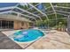 Inviting screened-in pool features a spa, tile deck, and lounge chairs is an ideal oasis for relaxation and entertainment at 1877 Muirfield Way, Oldsmar, FL 34677
