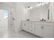 Bright bathroom with double vanity, modern fixtures, and a glass-enclosed walk-in shower at 2039 Amelia Bay Pl, Valrico, FL 33596