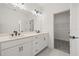 Elegant bathroom with a double sink vanity, sleek hardware, and a doorway to a walk-in closet at 2039 Amelia Bay Pl, Valrico, FL 33596