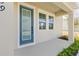 The home boasts a charming front porch with a stylish blue door, inviting windows, and manicured landscaping at 2039 Amelia Bay Pl, Valrico, FL 33596