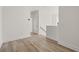 Hallway with wood floors leading to bedrooms and stairs featuring white walls and trim at 2039 Amelia Bay Pl, Valrico, FL 33596