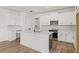 Bright kitchen showcasing a large island, white cabinets, quartz countertops, and stainless steel appliances at 2039 Amelia Bay Pl, Valrico, FL 33596