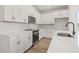 Modern kitchen featuring white cabinets, stainless steel appliances, and beautiful wood-look flooring at 2039 Amelia Bay Pl, Valrico, FL 33596
