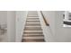 Bright staircase featuring wood steps, white risers, and a natural wood handrail in a modern home at 2039 Amelia Bay Pl, Valrico, FL 33596