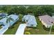 Aerial view of a single-story home with lush landscaping, a long driveway, and mature trees at 2121 Worthington Greens Dr, Sun City Center, FL 33573