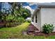 Landscaped backyard featuring lush greenery, mulch beds, and a well-maintained lawn at 2121 Worthington Greens Dr, Sun City Center, FL 33573