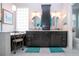Elegant bathroom featuring dual sinks, dark wood cabinets, marble countertops, and a glass block window at 2121 Worthington Greens Dr, Sun City Center, FL 33573