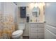 Bathroom with a white vanity, floral shower curtain, round mirror, and white tiled walls at 2121 Worthington Greens Dr, Sun City Center, FL 33573