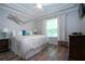 Inviting bedroom with tray ceiling, wood flooring, and large windows providing natural light at 2121 Worthington Greens Dr, Sun City Center, FL 33573
