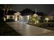 Beautiful single-story home with lush landscaping and an expansive driveway at nighttime at 2121 Worthington Greens Dr, Sun City Center, FL 33573