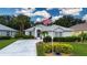 Charming single-story home featuring a well-manicured lawn, tasteful landscaping, and an American flag at 2121 Worthington Greens Dr, Sun City Center, FL 33573
