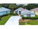 Charming single-story home featuring lush landscaping, a long driveway, and an American flag at 2121 Worthington Greens Dr, Sun City Center, FL 33573