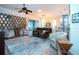 Cozy living room with wood flooring, modern furniture and a decorative mirror wall feature at 2121 Worthington Greens Dr, Sun City Center, FL 33573
