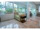 Bright sunroom featuring tile floors, neutral colored furniture, many windows looking out onto the backyard at 2121 Worthington Greens Dr, Sun City Center, FL 33573