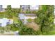 Overhead view reveals unique building layout, natural pond, ample parking, and lush surrounding foliage at 2174 62Nd N St, Clearwater, FL 33760