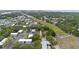 Aerial perspective shows housing with tree coverage, adjacent to open green area and utility poles at 2174 62Nd N St, Clearwater, FL 33760