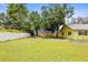 Well-maintained backyard featuring a lush lawn, mature trees, and a privacy fence at 2174 62Nd N St, Clearwater, FL 33760