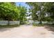 Wide driveway leading to a well-maintained home with lush greenery and a charming white picket fence at 2174 62Nd N St, Clearwater, FL 33760