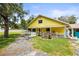 Charming yellow home featuring a cozy porch and well-maintained lawn at 2174 62Nd N St, Clearwater, FL 33760