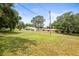 Spacious front yard with a view of the charming yellow home and surrounding greenery at 2174 62Nd N St, Clearwater, FL 33760