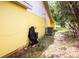 Exterior view of the yellow house, featuring the HVAC and lush greenery at 2174 62Nd N St, Clearwater, FL 33760