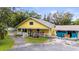 Lovely yellow home with a classic white picket fence and colorful landscaping around the front porch at 2174 62Nd N St, Clearwater, FL 33760