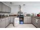 Well-lit kitchen featuring gray cabinets, granite countertops, and stainless steel appliances at 2174 62Nd N St, Clearwater, FL 33760