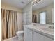 Bathroom features a double sink vanity, decorative shelving, and a shower with a curtain at 2527 Wrencrest Cir, Valrico, FL 33594