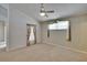 Spacious carpeted bedroom with windows dressed in floral and sheer curtains and a ceiling fan at 2527 Wrencrest Cir, Valrico, FL 33594