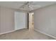 Neutral carpeted bedroom features a ceiling fan, a closet, and a door leading to a bathroom at 2527 Wrencrest Cir, Valrico, FL 33594