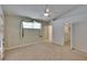 Neutral carpeted bedroom featuring a ceiling fan, window with curtains, and a walk-in closet for ample storage at 2527 Wrencrest Cir, Valrico, FL 33594