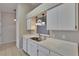 The kitchen features stainless steel appliances, white cabinets, and modern pendant lighting at 2527 Wrencrest Cir, Valrico, FL 33594