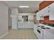 The bright, open kitchen offers white appliances and cabinets with a convenient breakfast bar at 2527 Wrencrest Cir, Valrico, FL 33594