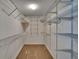 Walk-in closet with metal shelving and neutral carpeted floor, providing ample storage space at 2527 Wrencrest Cir, Valrico, FL 33594