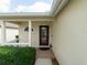 Inviting front porch with decorative columns and a glass-paneled front door with nice landscaping at 31201 Shaker Cir, Wesley Chapel, FL 33543