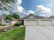 Well-maintained single-story home with a two-car garage, green lawn, and established landscaping at 31201 Shaker Cir, Wesley Chapel, FL 33543