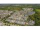Aerial view showcases a neighborhood's layout and location with lake, trees, and residential properties at 32718 Harmony Oaks Dr, Wesley Chapel, FL 33545