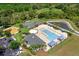 Aerial view of a community pool area with a playground, basketball court, and lounge chairs at 32718 Harmony Oaks Dr, Wesley Chapel, FL 33545