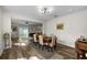 Inviting dining area with wood-look flooring, modern lighting, and stylish decor adjacent to the living room at 32718 Harmony Oaks Dr, Wesley Chapel, FL 33545