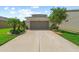 Exterior view of a two-story home with a concrete driveway and well-maintained landscaping at 32718 Harmony Oaks Dr, Wesley Chapel, FL 33545
