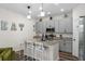 Well-equipped kitchen with gray cabinets, granite countertops, and an island with bar seating, perfect for casual dining at 32718 Harmony Oaks Dr, Wesley Chapel, FL 33545